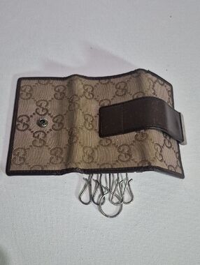 A Gucci GG monogram canvas 6-ring key holder with brown leather trim.